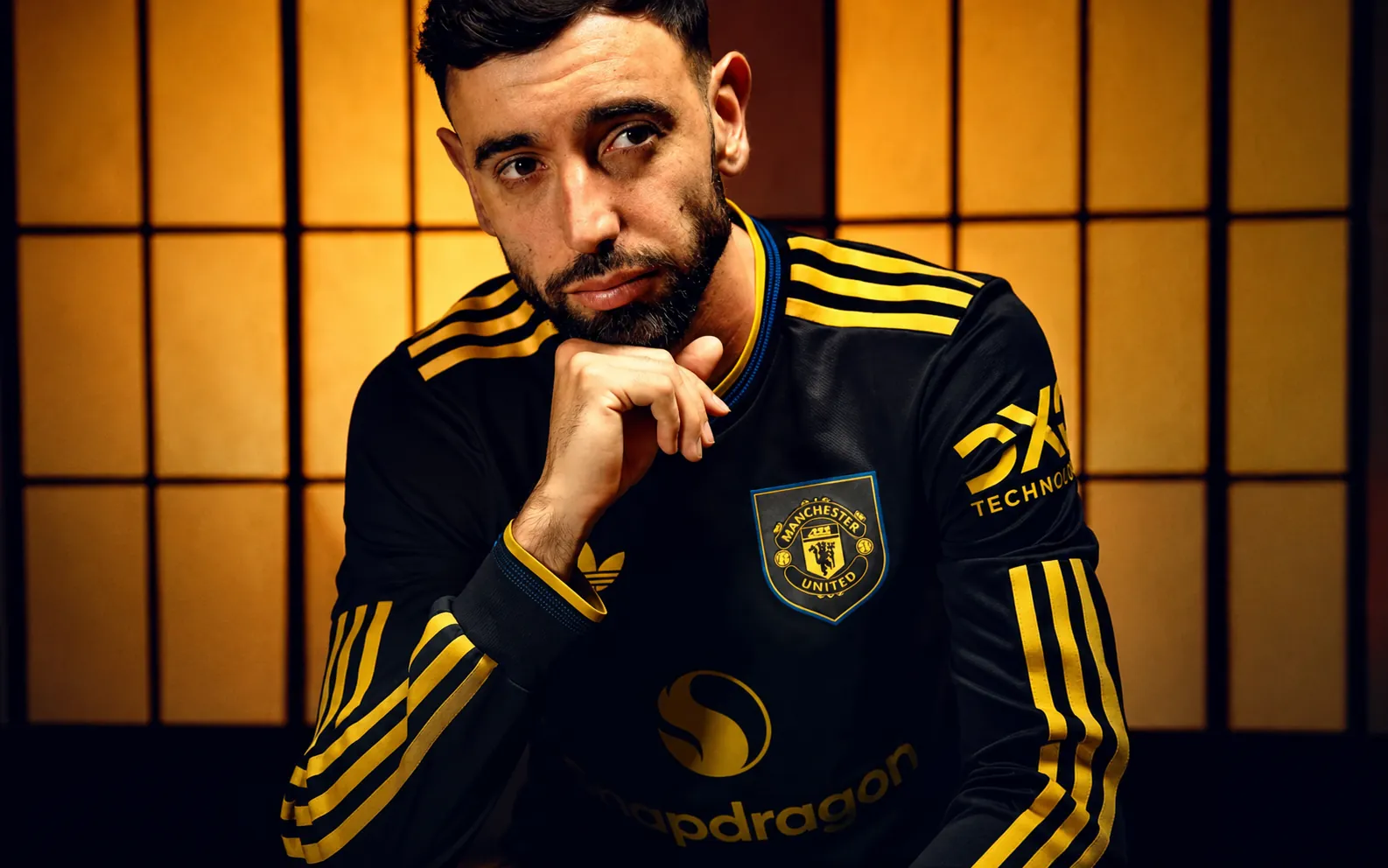 Manchester United football jersey with player in black and yellow kit