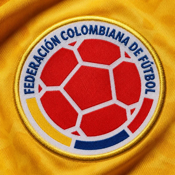 Colombia football crest on yellow jersey fabric background