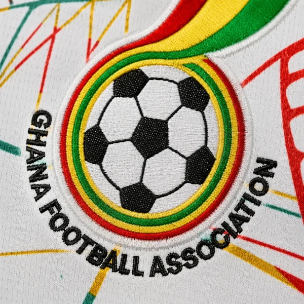Ghana football crest on white jersey fabric background