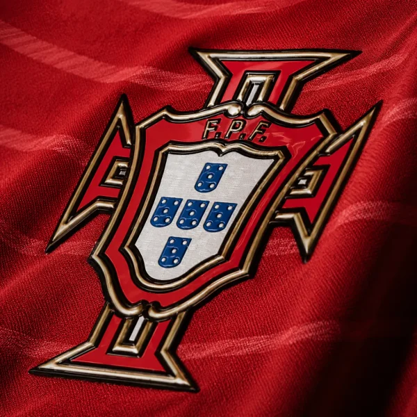 Portugal football crest on red jersey fabric background